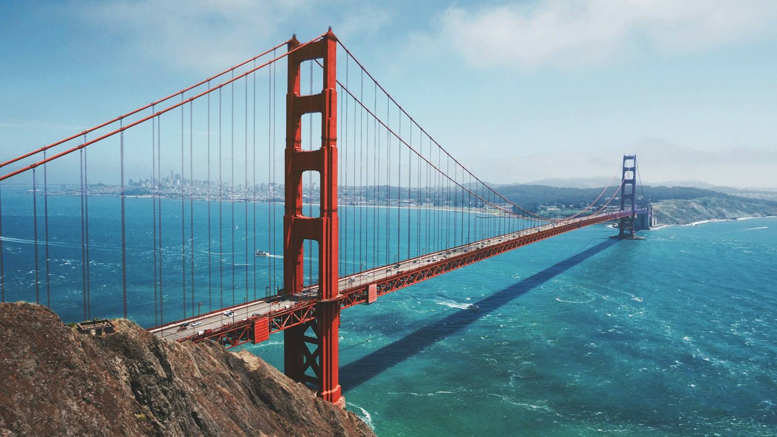 A suspension bridge spanning the water at dusk, representing NPX's San Francisco origin